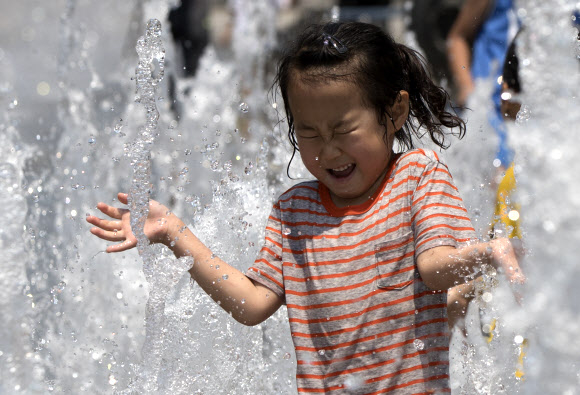 내륙지역을 중심으로 폭염특보가 확대 강화된 18일 오후 서울 광화문광장에서 어린이들이 물놀이를 하고 있다.  연합뉴스