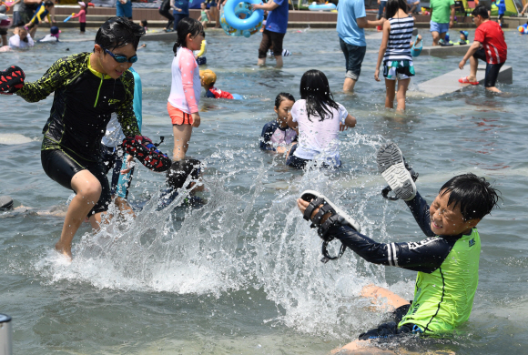 전국 곳곳에 폭염주의보와 경보가 발령된 18일 오후 서울 여의도 물빛광장을 찾은 어린이들이 물놀이를 하며 더위를 식히고 있다.  도준석 기자 pado@seoul.co.kr
