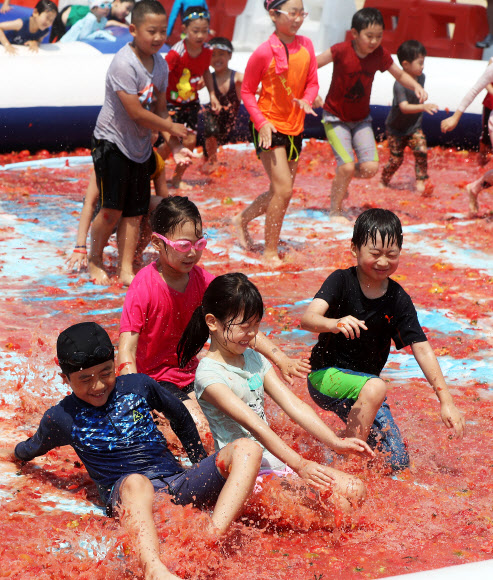 토마토 풀장에서 슬라이딩 하는 어린이들