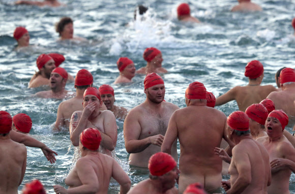 21일(현지시간) 호주 태즈메이니아 호바트에서 열린 겨울 축제인 ‘Dark Mofo’중 ‘동지맞이 누드 수영대회(Nude Solstice Swim)’ 참가자들이 발가벗은 채 수영을 즐기고 있다. EPA 연합뉴스