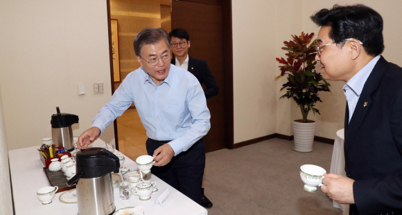 문재인 대통령이 22일 오전 청와대에서 열린 수석 보좌관회의에서 직접 커피를 들고 자리로 향하고 있다. 안주영 기자 jya@seoul.co.kr