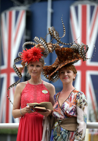 레이스고어들이 22일(현지시간) 영국 런던 애스콧 Royal Ascot horse racing meet에서 열린 ‘여성 초대일(Ladies Day)’에 참석해 화려한 모자를 뽐내고 있다. AFP 연합뉴스