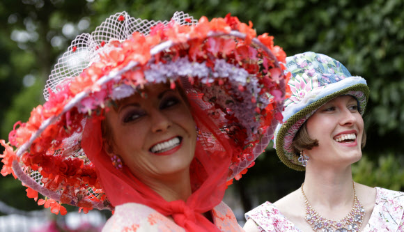 레이스고어들이 22일(현지시간) 영국 런던 애스콧 Royal Ascot horse racing meet에서 열린 ‘여성 초대일(Ladies Day)’에 참석해 화려한 모자를 뽐내고 있다. AP 연합뉴스