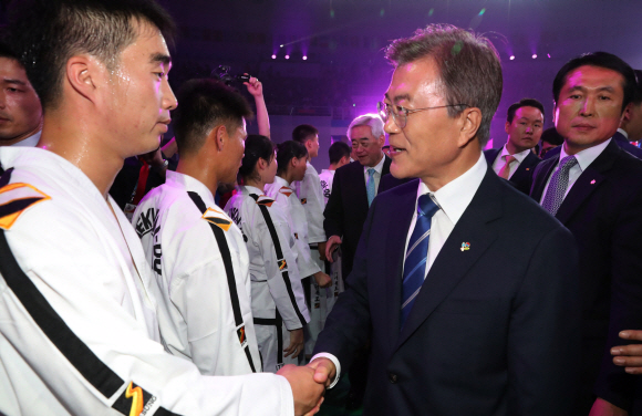 문재인 대통령이24일 오후 전북 무주 태권도원에서 열린  WTF 세계태권도선수권대회 개막식을 마친 뒤 북한 시범단원과 악수를  하고 있다. 2017.6.24.청와대사진기자단