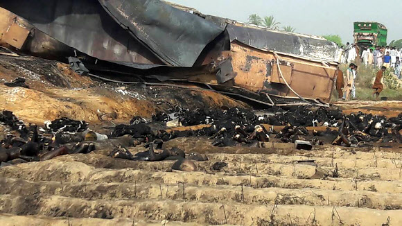 25일(현지시간) 오전 파키스탄 동부 물탄시에서 남서쪽으로 100㎞ 떨어진 바하왈푸르 지역 고속도로에서 전복된 유조차가 폭발하면서 불에 탄 인근 주민들의 시신이 유조차 잔해 주위에 흩어져 있다. 폭발은 담배꽁초의 불로 발생한 것으로 추정되는 가운데 주민들이 기름을 얻기 위해 유조차로 몰려들면서 최소 123명이 사망했다. 바하왈푸르 AFP 연합뉴스