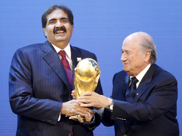 제프 블라터 국제축구연맹(FIFA) 회장이 지난 2010년 12월 2일 스위스 취리히에서 2022년 월드컵 개최지로 선정된 카타르의 셰이크 하마드 빈칼리파 알타니 국왕(에미르)에게 월드컵 트로피를 건네고 있다. AP 자료사진 연합뉴스