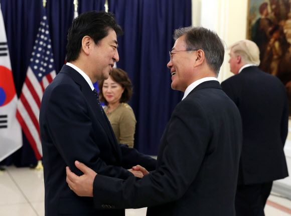 문재인 대통령과 아베 신조 일본 총리가 6일 오후(현지시간) G20 정상회의가 열리는 독일 함부르크 시내 미국총영사관에서 열리는 한미일 정상만찬에서 악수하고 있다.  연합뉴스