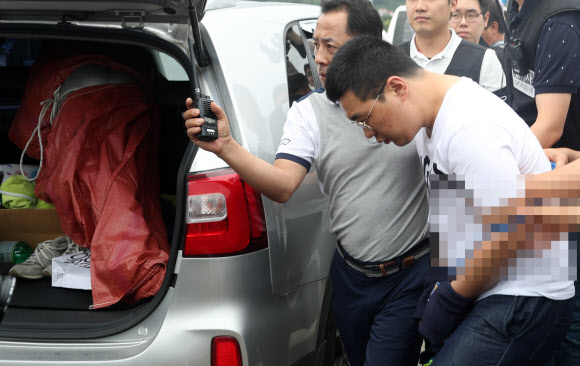 창원에서 발생한 ’골프연습장 40대 주부 납치·살해’ 사건 피의자 심천우가 7일 오후 시체를 유기한 진주시 진수대교에서 현장검증하고 있다.  연합뉴스