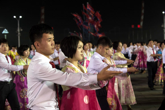 6일 북한 평양 김일성광장에서 대륙간탄도미사일(ICBM)급으로 평가받는 ’화성-14형’의 시험발사 성공을 기념해 청년학생들이 야회(무도회)를 벌이고 있다. AFP 연합뉴스