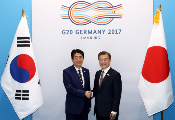 문재인 대통령과 아베 신조 일본 총리가 7일 오전(현지시간) 독일 함부르크 G20 정상회의장 메세홀 양자회담장에서 열린 한-일 정상회담에서 악수하고 있다.  연합뉴스