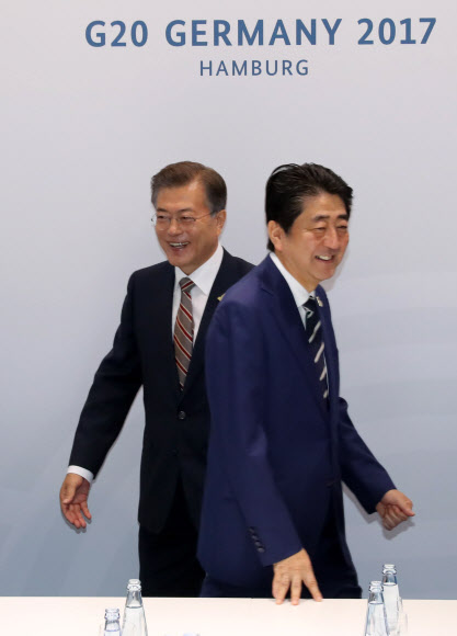 문재인 대통령과 아베 신조 일본 총리가 7일 오전(현지시간) 독일 함부르크 G20 정상회의장 메세홀 양자회담장에서 열린 한-일 정상회담에서 악수한 뒤 자리로 향하고 있다.  연합뉴스