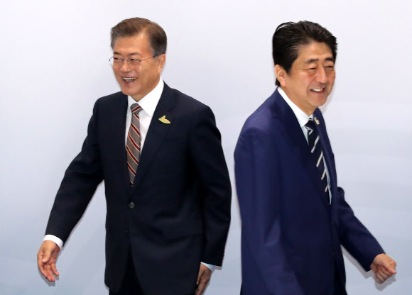 문재인 대통령과 아베 신조 일본 총리가 7일 오전(현지시간) 독일 함부르크 G20 정상회의장 메세홀 양자회담장에서 열린 한-일 정상회담에서 악수한 뒤 마련된 자리로 가고 있다.  연합뉴스