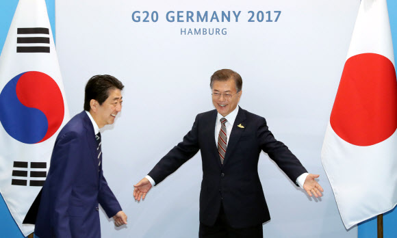 문재인 대통령과 아베 신조 일본 총리가 7일 오전(현지시간) 독일 함부르크 G20 정상회의장 메세홀 양자회담장에서 열린 한-일 정상회담에서 악수한 뒤 자리로 향하고 있다.  연합뉴스