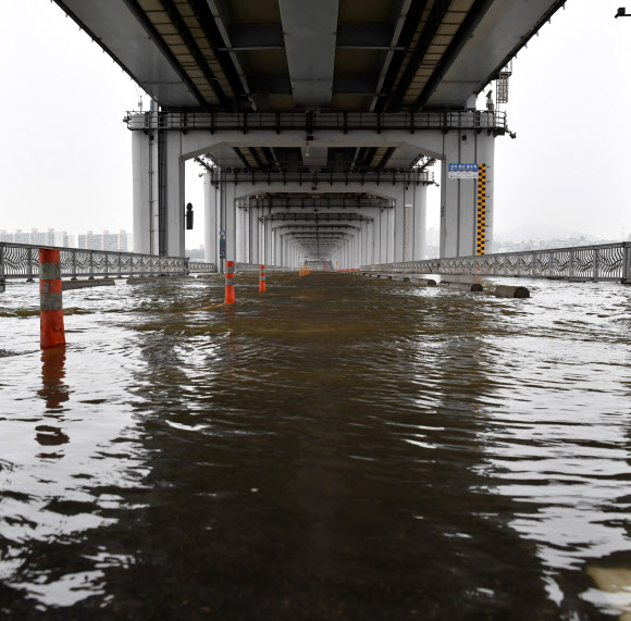 중부지방 호우로 인해 수위 상승으로 팔당댐을 비롯한 한강 수계 댐들이 방류를 하고 있는 11일 오전 서울 잠수교가 한강 수위 상승으로 잠겨 통행이 전면 통제되고 있다. 연합뉴스