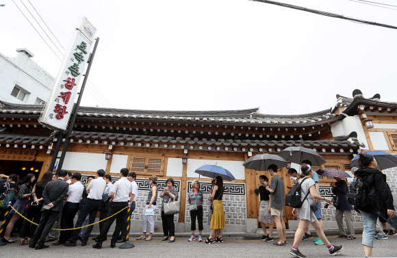 초복인 12일 오전 서울 종로구의 한 삼계탕집 앞에서 삼계탕을 먹기 위해 손님들이 줄지어 기다리고 있다.  연합뉴스