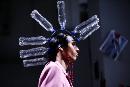 12일(현지시간) 미국 뉴욕에서 열린 맨즈 패션위크에서 산체스-케인(Sanchez-Kane)의 의상을 입은 모델이 머리에 페트병 장식을 하고 런웨이를 걷고 있다.<br>AP 연합뉴스