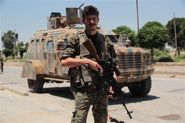 쿠르드 민병대인 ‘인민수비대’에 자원한 로버트 그로트가 군복과 총을 든 채 포즈를 취하고 있다. 쿠르드 인민수비대