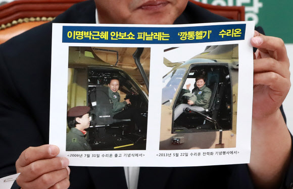 국민의당 이찬열 의원이 19일 오전 국회 당대표실에서 열린 비상대책위원회의에 참석해 이명박, 박근혜 전 대통령이 한국항공우주산업(KAI)이 생산한 수리온 헬기에 탑승한 사진을 들어보이고 있다.  연합뉴스