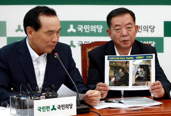 국민의당 김중로 의원(왼쪽)과 이찬열 의원이 19일 오전 국회 당대표실에서 열린 비상대책위원회의에 참석해 이명박, 박근혜 전 대통령이 한국항공우주산업(KAI)이 생산한 수리온 헬기에 탑승한 사진을 들고 발언하고 있다.  연합뉴스