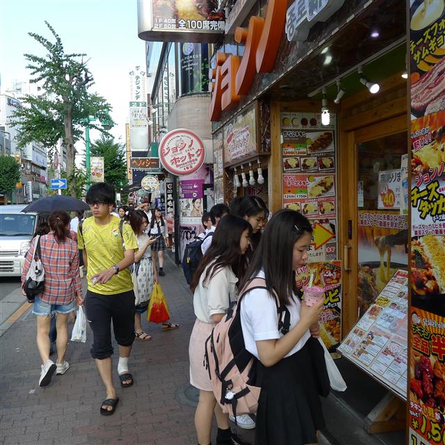 치즈 닭갈비 등 한국 음식점의 메뉴판을 살펴보고 있는 일본 젊은이들.