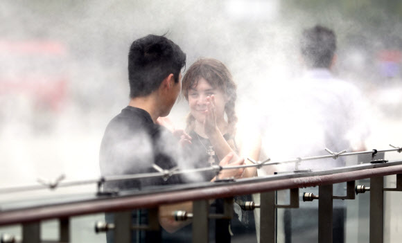 물안개속 더위 식히는 외국인 관광객