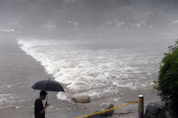 서울 경기 지역에 집중호우가 쏟아진 23일 경기도 포천시 이도면의 한 캠핑장으로 들어가는 다리가 불어난 강물에 잠겨 캠핑족들이 고립이 되어 있다. 2017. 7. 23 정연호 기자 tpgod@seoul.co.kr