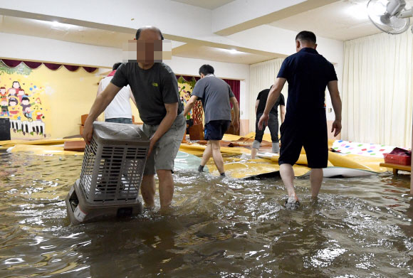 23일 인천 남구 주안4동에서 갑작스럽게 내린비로 교회가 침수되자 교인들이 물을 빼고 있다. 2017.9.23 박지환기자 popocar@seoul.co.kr