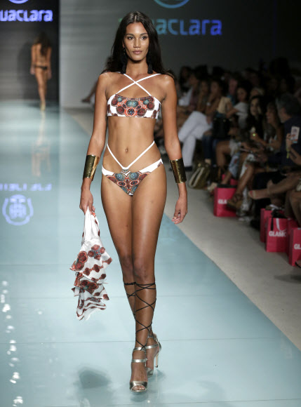 모델이 22일(현지시간) 미국 플로리다주 마이애미비치에서 열린 스윔 위크 중 FUNKSHION 패션쇼에서 Agua Clara 수영복을 입고 런웨이를 걷고 있다. AP 연합뉴스
