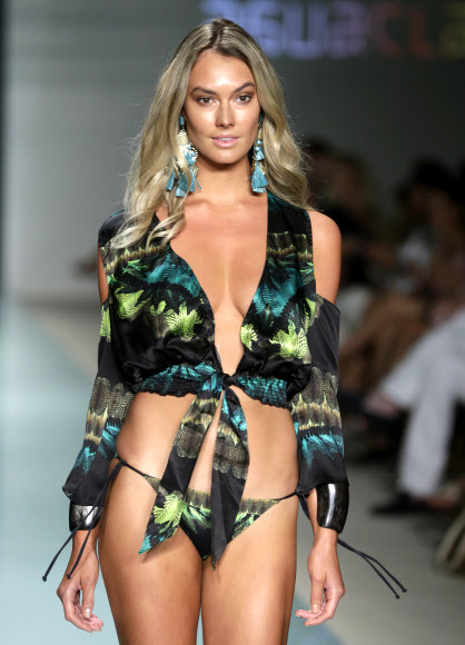 모델이 22일(현지시간) 미국 플로리다주 마이애미비치에서 열린 스윔 위크 중 FUNKSHION 패션쇼에서 Agua Clara 수영복을 입고 런웨이를 걷고 있다. AP 연합뉴스