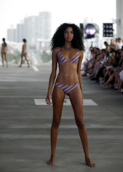 모델이 22일(현지시간) 미국 플로리다주 마이애미비치 주차장에서 열린 스윔 위크 중 FUNKSHION 패션쇼에서 Acacia 수영복을 입고 런웨이를 걷고 있다. AP 연합뉴스