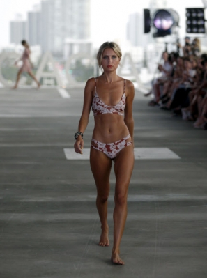 모델이 22일(현지시간) 미국 플로리다주 마이애미비치 주차장에서 열린 스윔 위크 중 FUNKSHION 패션쇼에서 Acacia 수영복을 입고 런웨이를 걷고 있다. AP 연합뉴스