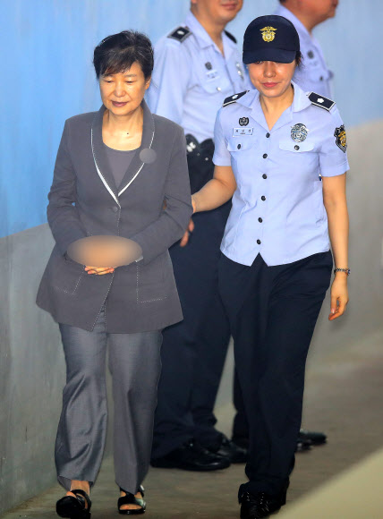 박근혜 전 대통령이 24일 오전 서울 서초동 서울중앙지법에서 열린 공판에 참석하기 위해 법원에 도착한 뒤 교도관과 함께 구치감으로 향하고 있다.  연합뉴스