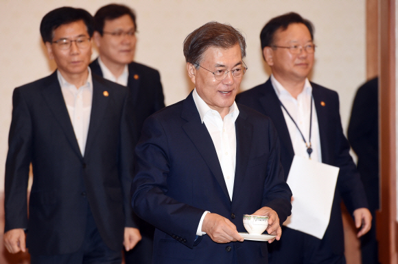 문재인 대통령이 25일 오전 청와대에서 열린 국무회의에 찻잔을 들고 입장하고 있다.  안주영 기자 jya@seoul.co.kr