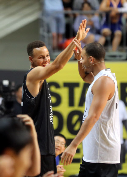 27일 서울 장충체육관에서 열린 ’언더아머-스테판 커리 라이브 인 서울’행사에서 스테판 커리가 동생 세스 커리와 하이파이브 하고 있다.   연합뉴스