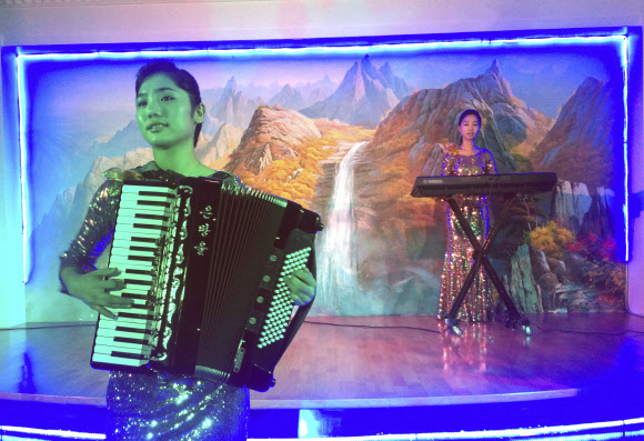 25일(현지시간) 두바이에 위치한 북한 식당 옥류관에서 종업원들이 공연을 펼치고 있다. 북한이 운영하는 식당부터 건설 현장까지, 북한 노동자들은 쿠웨이트, 오만, 카타르, UAE에서 강제노동에 가까운 근로조건에 노출돼 있으며 고정된 정보요원들의 감시를 받고 음식을 거의 먹지 못한 채 육체적 학대에도 시달리고 있다고 당국자들은 말했다.  AP 연합뉴스