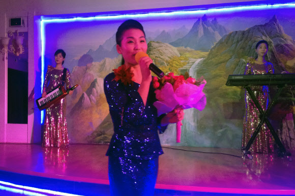 25일(현지시간) 두바이에 위치한 북한 식당 옥류관에서 종업원들이 공연을 펼치고 있다. 북한이 운영하는 식당부터 건설 현장까지, 북한 노동자들은 쿠웨이트, 오만, 카타르, UAE에서 강제노동에 가까운 근로조건에 노출돼 있으며 고정된 정보요원들의 감시를 받고 음식을 거의 먹지 못한 채 육체적 학대에도 시달리고 있다고 당국자들은 말했다.  AP 연합뉴스