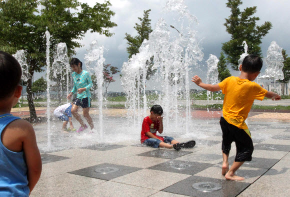 낮 기온이 32도까지 오른 30일 충남 태안군 태안읍의 한 도로변에 조성된 바닥분수에서 아이들이 물놀이를 하며 놀고 있다.  연합뉴스