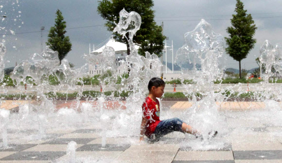 낮 기온이 32도까지 오른 30일 충남 태안군 태안읍의 한 도로변에 조성된 바닥분수에서 아이들이 물놀이 하고 있다.  연합뉴스