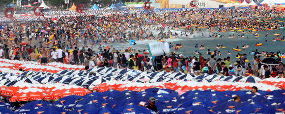 본격적인 휴가철을 맞은 30일 오후 부산 해운대구 해운대해수욕장에서 피서객들이 물놀이를 즐기고 있다.  연합뉴스
