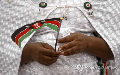 대선을 앞둔 케냐의 한 시민이 케냐 소형 국기를 들고 있다. AP=연합뉴스