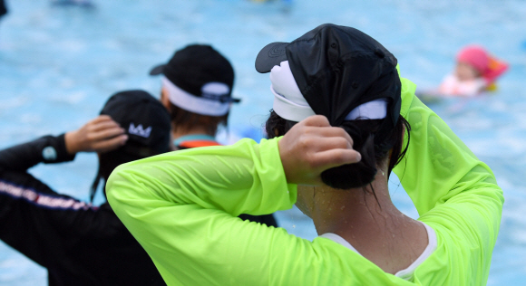 1일 서울의 한 한강 수영장에서 이용객들이 수영모를 착용한 채 야구모자를 쓰고 있다. 한강수영장에서는 수영모를 착용하지 않으면 물 안에 들어갈 수 없다. 박윤슬 기자 seul@seoul.co.kr
