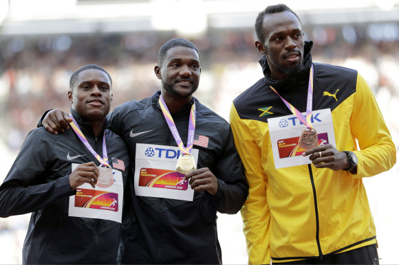 뭔가 낯설다. 저스틴 개틀린(가운데)이 7일 남자 100m 메달 시상식에서 크리스티안 콜먼(왼쪽 은메달), 우사인 볼트(동메달)과 나란히 금메달을 들어 보이고 있다. 런던 AP 연합뉴스