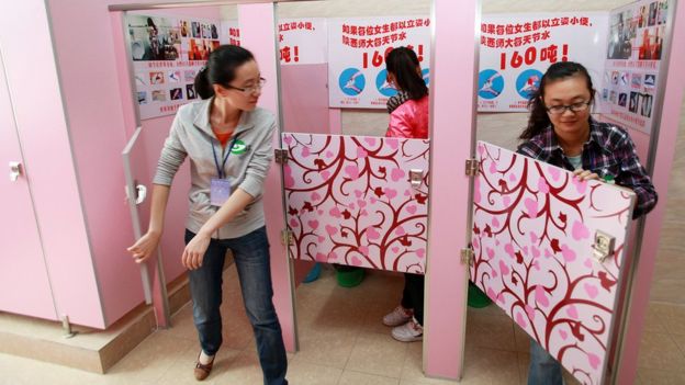 중국 시안에 있는 산시보통대학 여학생들이 지난 2010년 9월 26일 어떻게 서서 볼일을 볼 수 있는지 알려주는 안내가 게재된 분홍빛 칸막이방 화장실을 이용하고 있다. AFP 자료사진 