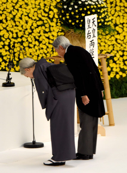 일본 종전일(패전일)인 15일 도쿄 부도칸(武道館)의 ’전국전몰자추도식’에 참석한, 아키히토 일왕 내외가 전몰자들에 대해 예를 표하며 고개를 숙이고 있다. 도쿄 AFP 연합뉴스