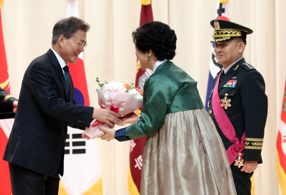 문재인 대통령이 20일 오후 국방부에서 열린 합참의장 이ㆍ취임식 행사에서 이순진 이임 합참의장(오른쪽)의 부인 박경자 씨에게 꽃다발을 전달하고 있다. 2017.8.20