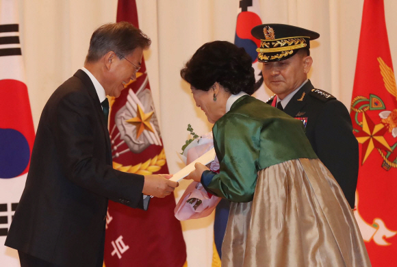 문재인 대통령이 20일 국방부에서 열린 합참의장 이취임식에서 퇴임하는 이순진 전 합장의장 내외에게 캐다나 항공권을  전달하고 있다. 청와대사진기자단