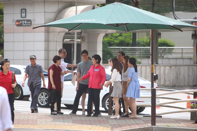 조은희 서초구청장(분홍 잠바)이 22일 서초구청 앞 횡단보도 인근에 설치된 그늘막에서 교통신호가 바뀌기를 기다리는 주민들과 담소를 하고 있다.<br>서초구 제공