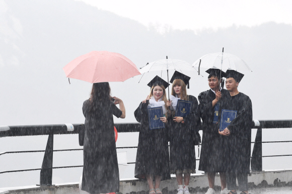 23일 서울 종로구 상명대학교에서 후기 졸업식에 참가한 졸업생들이 우산을 쓴채 기념촬영을 하고 있다. 2017.8.23 도준석 기자 pado@seoul.co.kr