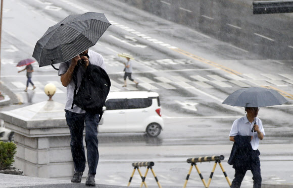 강원 일부 내륙지방에 호우주의보가 발효된 24일 오전 강원 춘천시 법원삼거리에서 우산을 쓴 시민들이 출근길을 재촉하고 있다.  연합뉴스