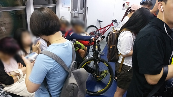 지난 26일 오전 사당역에서 당고개역 방면으로 달리는 지하철 객차 맨 앞칸에 한 승객이 자신의 앞에 자전거를 세우고 자리에 앉아 있다. 
